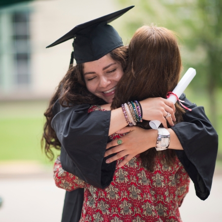 Girl Graduate Hugging Family member
