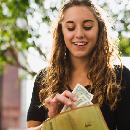 teen smiling with money