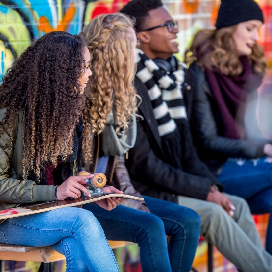 a group of teens by colorful wall 