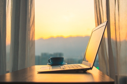 laptop by window sunset