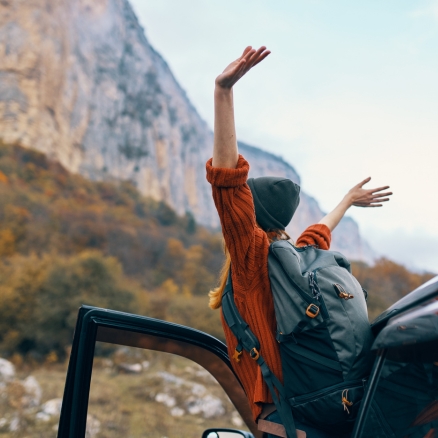 person with arms up out of car