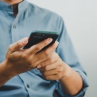 man in blue shirt on phone