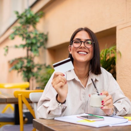 Woman in glasses holding credit card