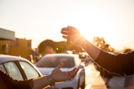 one person handing another person a car key