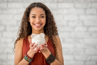 Teen girl holding piggy bank