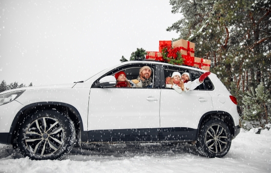 family in a car with presents on top