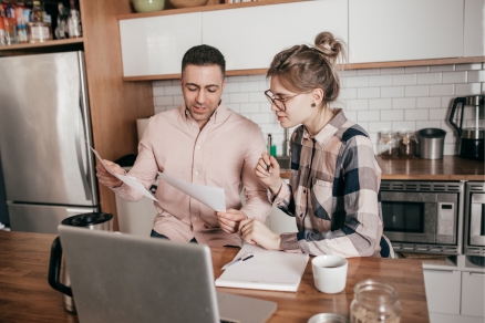 two people in kitchen looking at papers