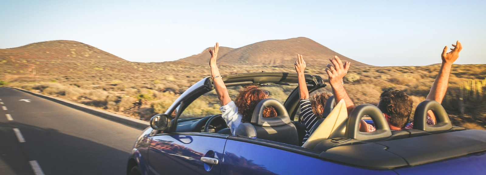 three people in a convertable car