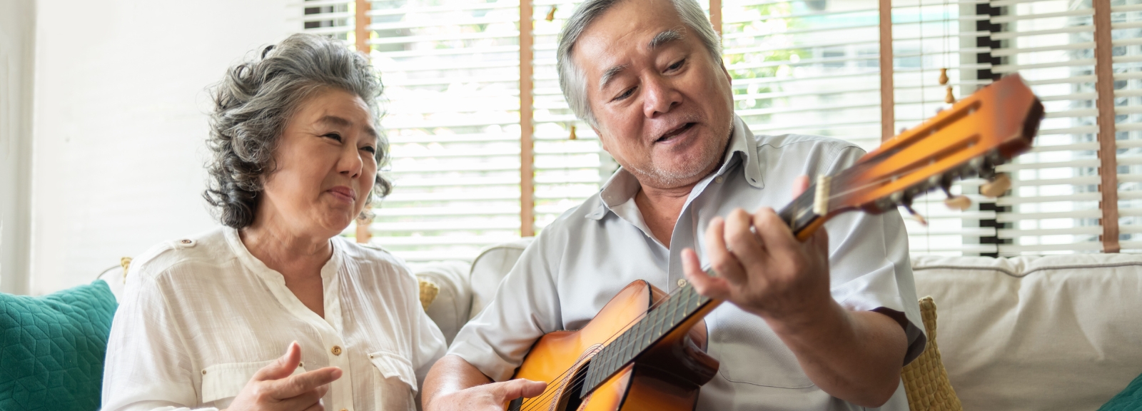 Man playing guitar sitting by woman