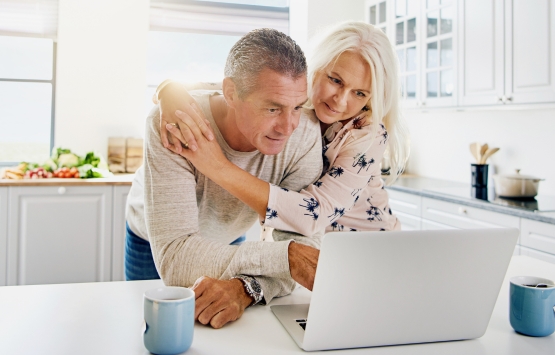 Couple in kitchen on computer