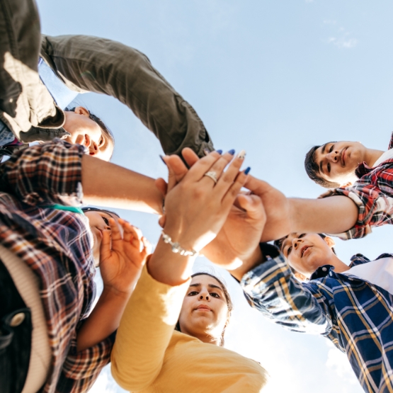 teens with hands in circle