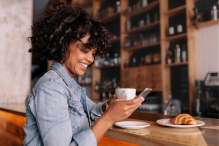 woman at cafe smiling at phone