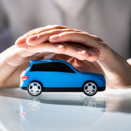 two hands covering a blue car