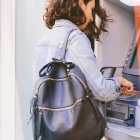 woman with backpack at an ATM