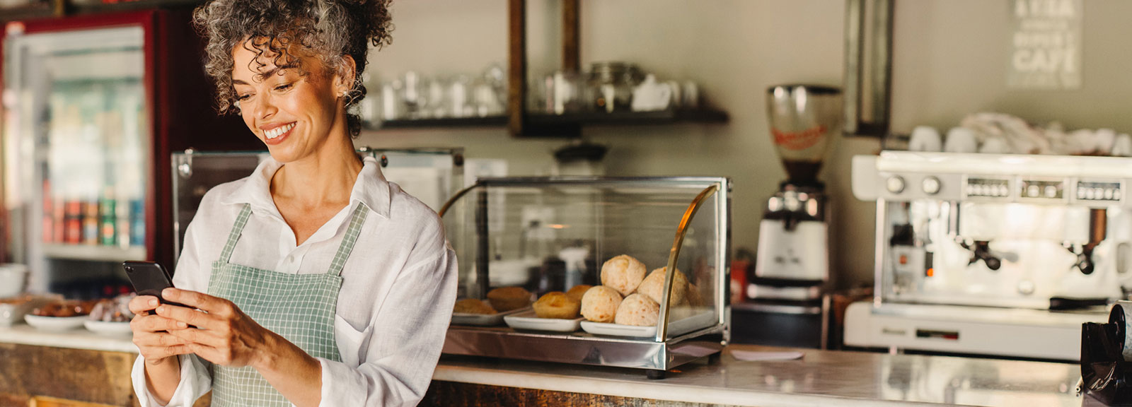 Business woman using phone in her restaurant