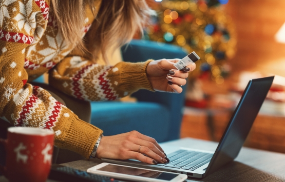 Person in sweater holding credit card 