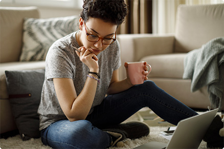 Young woman working on laptop in living room