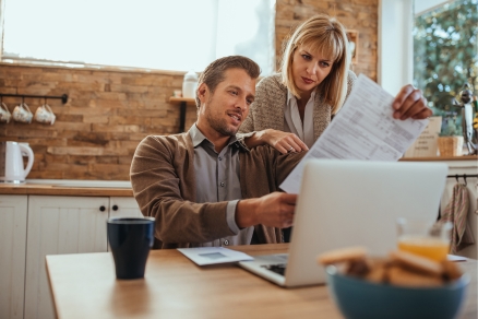 couple in kitchen paying bills