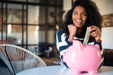 woman putting money in piggy bank