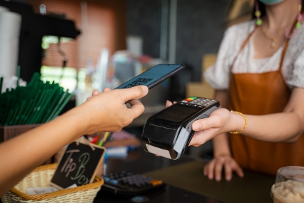 person paying at cafe with phone